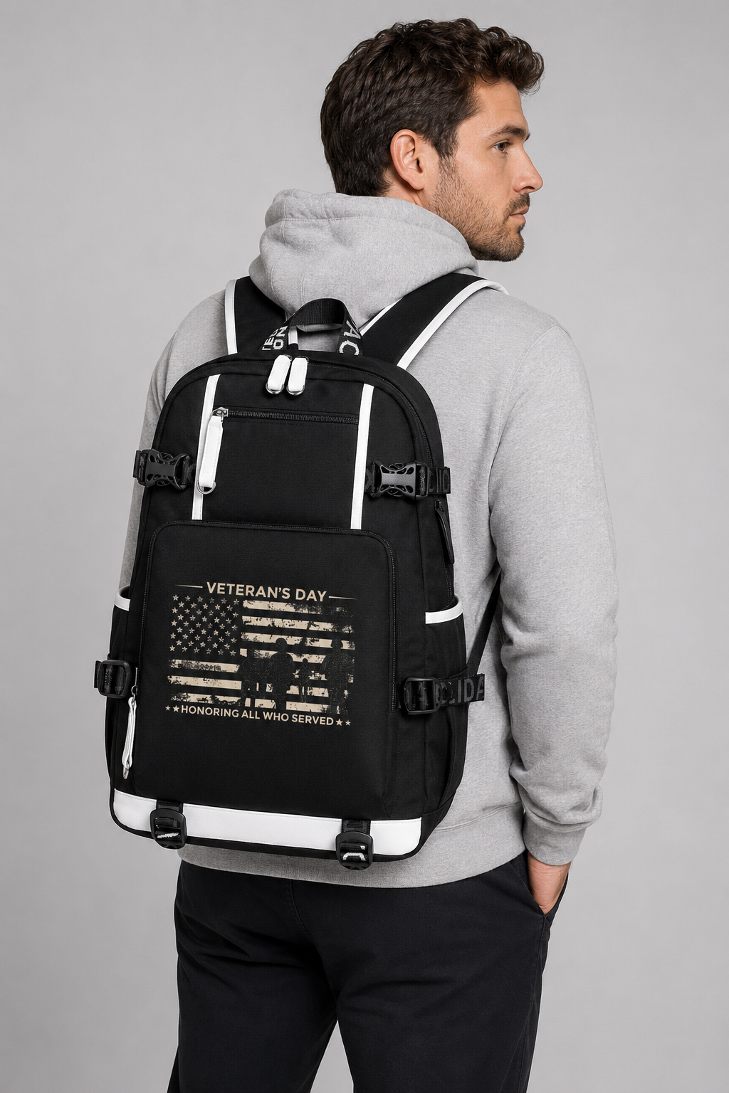 Adult model wearing Veterans Day Honoring All Who Served black backpack, three-quarter rear view