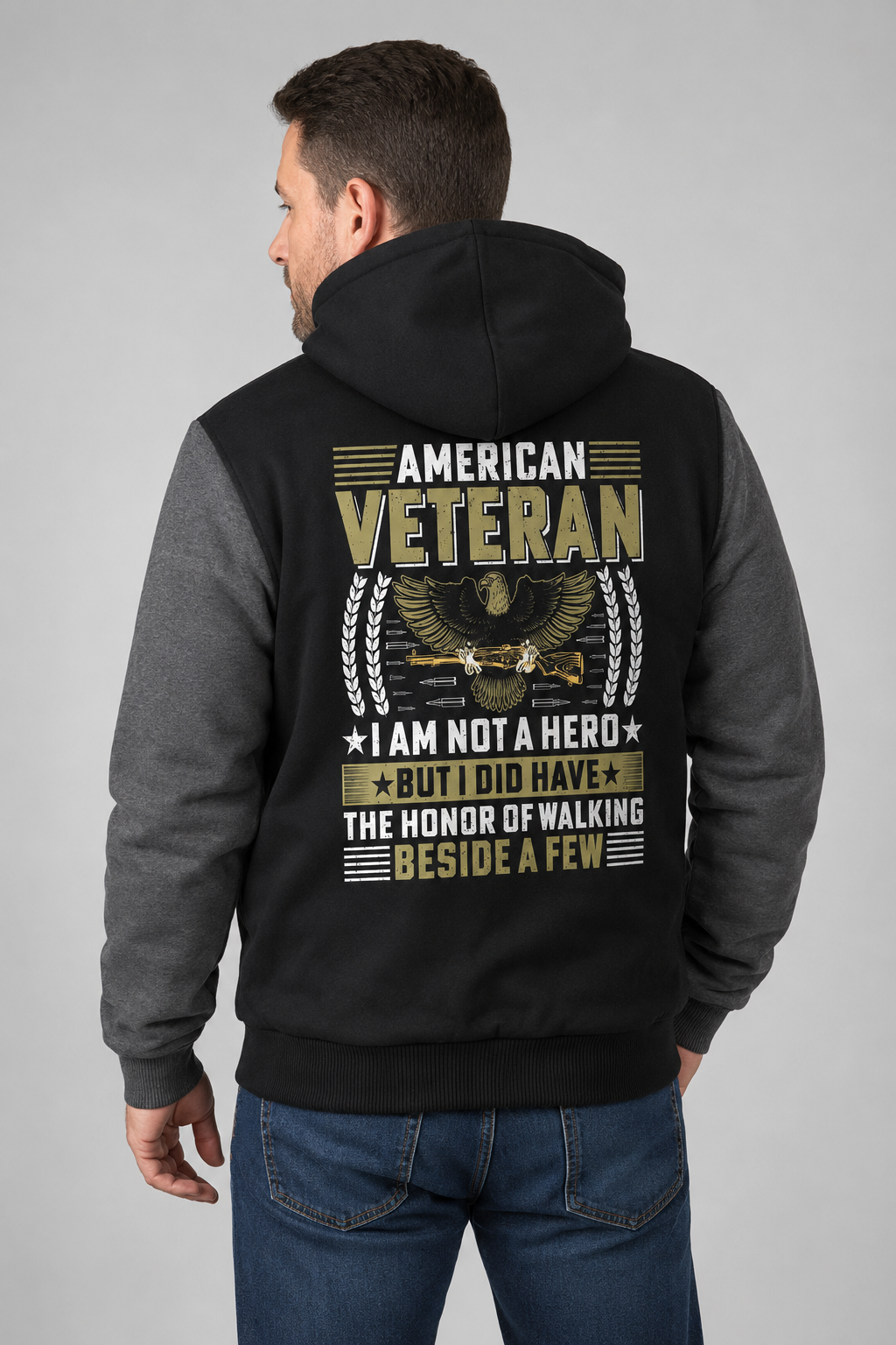 Adult model wearing American Veteran I Am Not a Hero black and gray fleece jacket, three-quarter back view