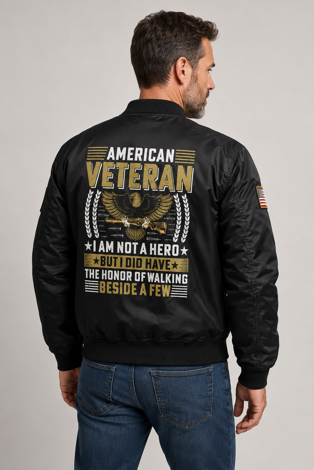 Adult model wearing American Veteran I Am Not a Hero black bomber jacket, three-quarter back view